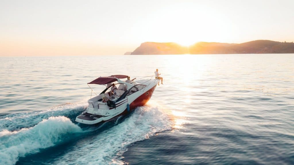 man riding on white and red boat on sea during daytime